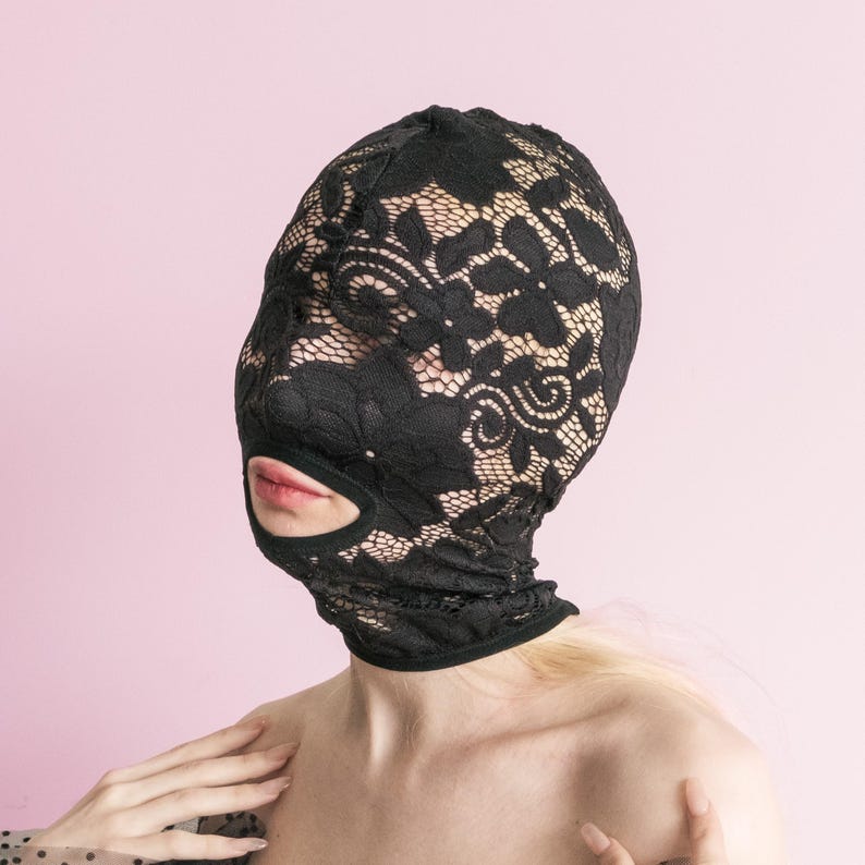 A handmade black full-face mask, only the mouth is visible. 67